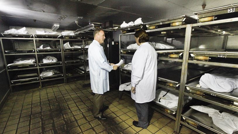 Montgomery County Coroner Dr. Kent Harshbarger, left, and pathology technician Michelle Welch are seen in the cooler at the morgue where an increase in drug overdose deaths has been reported. CHRIS STEWART / STAFF