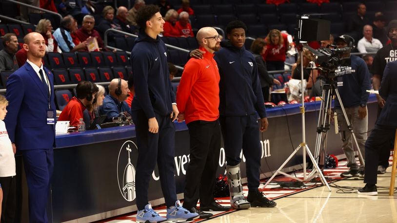Dayton's Koby Brea, left, and Malachi Smith stand with strength coach Casey Cathrall on Monday, Nov. 7, 2022, before a game against Lindenwood at UD Arena. David Jablonski/Staff
