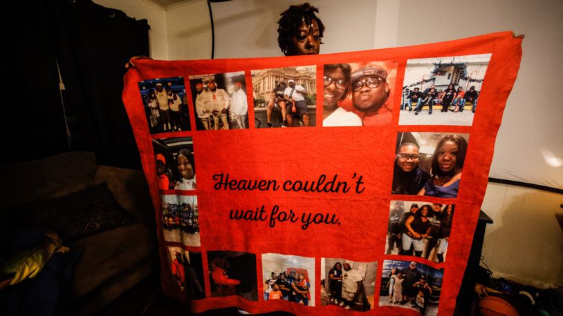 Ira Butler holds-up a blanket of remembrance of her late fiance, Willie Edwards. JIM NOELKER/STAFF