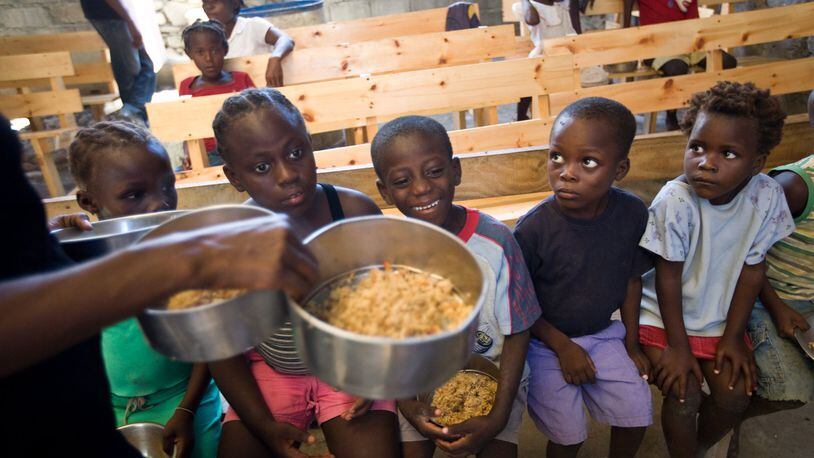 Haitian orphans patiently wait for meals inside a church supplied by A Child’s Hope International. CONTRIBUTED