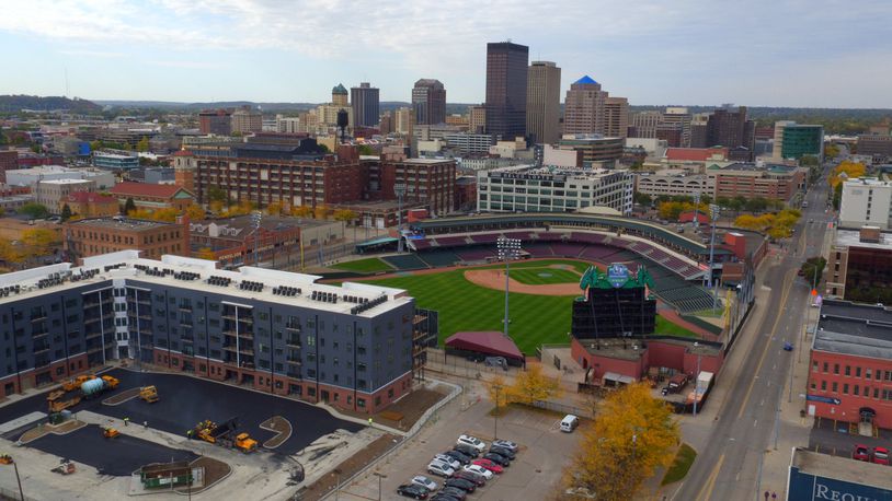 A view of the Water Street District and downtown Dayton. The Centerfield Flats, the blue and red apartment building, is expected to open next month. The Delco Lofts, on the other side of Fifth Third Field, opened in 2017, offering 133 units. Developer Crawford Hoying, in partnership with Woodard Development, plans to redevelop the massive Mendelsons liquidation outlet building just south of the ballpark and Delco apartments. JAROD THRUSH / STAFF