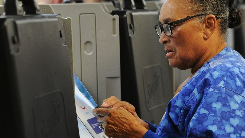 Alana Harrison checks over her ballot while voting Wednesday Oct. 12, 2022 at the Montgomery County Board of Elections. Early voting started Wednesday in Ohio. Election officials expect a large turnout of early voters this year. MARSHALL GORBY\STAFF