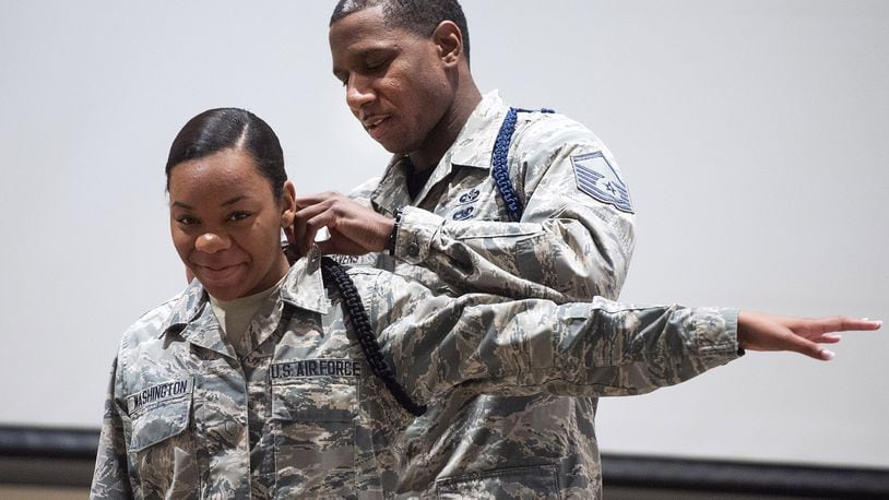 Master Sgt. Michael J. Stevens, U.S. Air Force School of Aerospace Medicine Military Training Flight chief, pins on Airman Chiara Washington a black rope signifying her as a member of the school s drill team July 7 on Wright-Patterson Air Force Base. Stevens was named as one of the Air Force s 12 Outstanding Airmen of the Year. (U.S. Air Force photo/R.J. Oriez)
