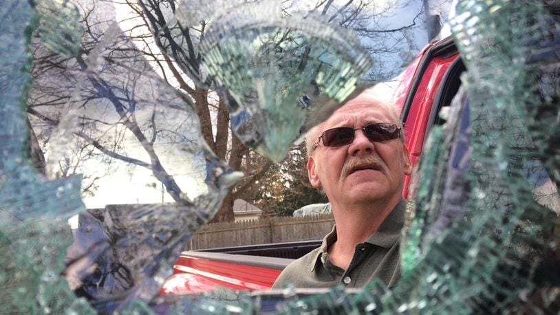 William Domer, of South Belmont Avenue, looks at the window shattered by a thief who broke into the truck that was sitting in his driveway. (Allison Wichie/Staff)
