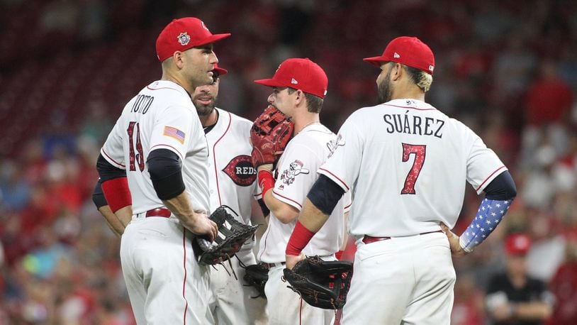 Reds infielders (left to right) Joey Votto, Jose Peraza, Scooter Gennett and Eugenio Suarez gather during a game against the White Sox on July 2, 2018, at Great American Ball Park in Cincinnati. David Jablonski/Staff