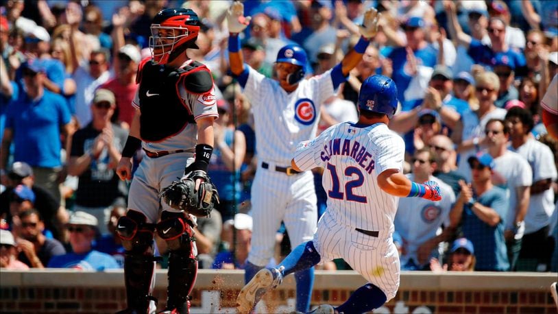 CHICAGO, IL - JULY 07:  Kyle Schwarber #12 of the Chicago Cubs scores on an RBI double against the Cincinnati Reds hit by Victor Caratini #7 (not pictured) during the fourth inning at Wrigley Field on July 7, 2018 in Chicago, Illinois.  (Photo by Jon Durr/Getty Images)