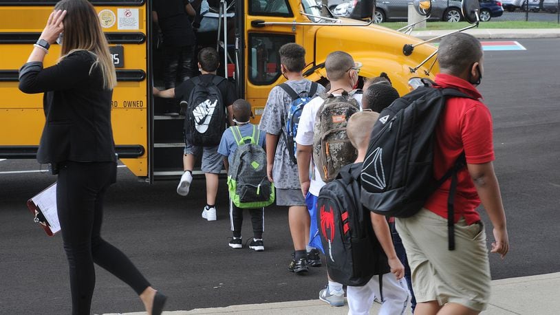 Students at Eastmont elementary in Dayton wait to board the bus at the end of the first day of school on Wednesday Aug. 18, 2021. MARSHALL GORBY\STAFF