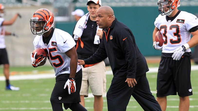 Cincinnati Bengals running back coach Hue Jackson works with rookie Giovani Bernard (25) during day two of rookie minicamp on Saturday, May 11, 2013. NICK DAGGY / STAFF