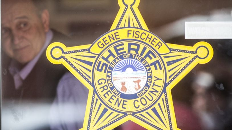 Greene County Sheriff Gene Fischer is seen Monday, April 27, 2020, through the glass door of the sheriff's office bearing his name. JIM NOELKER/STAFF