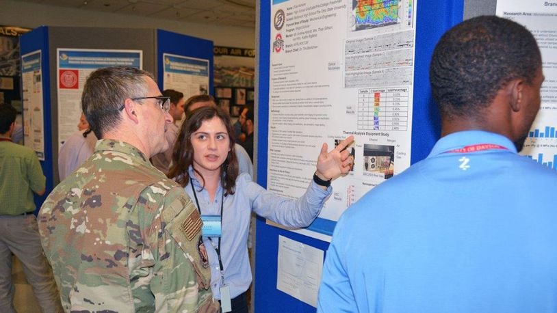 Elise Kemper, a 2019 Belbrook High School graduate, presents her research poster to Maj. Gen. William T. Cooley, commander of the Air Force Research Laboratory, at the summer student research poster session Aug. 1. Kemper’s research area this summer was polymeric matrix composites. She will be attending Ohio State University this fall, studying mechanical engineering. (U.S. Air Force photo/Spencer Deer)