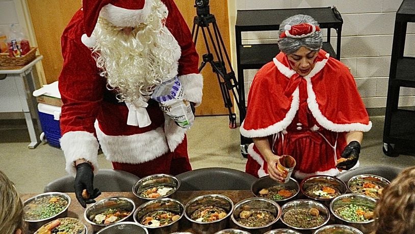 Santa and Mrs. Claus, aka Michael and Maria Ochs, prepare holiday meals for shelter dogs at the Montgomery County  Animal Resource Center. Bahati & Frey’s Place, a local dog daycare and training club, donated “ holiday dinner “ Friday, Dec. 30, 2022, to nearly 100 dogs being cared for by ARC. The meals consisted of turkey with gravy, mashed potatoes, green beans, carrots peas, oat and peanut butter cookies, acorn squash, blueberries, pumpkin cupcakes and apple Kong. The dinner was postponed from last week due to the winter storm. MARSHALL GORBY \STAFF