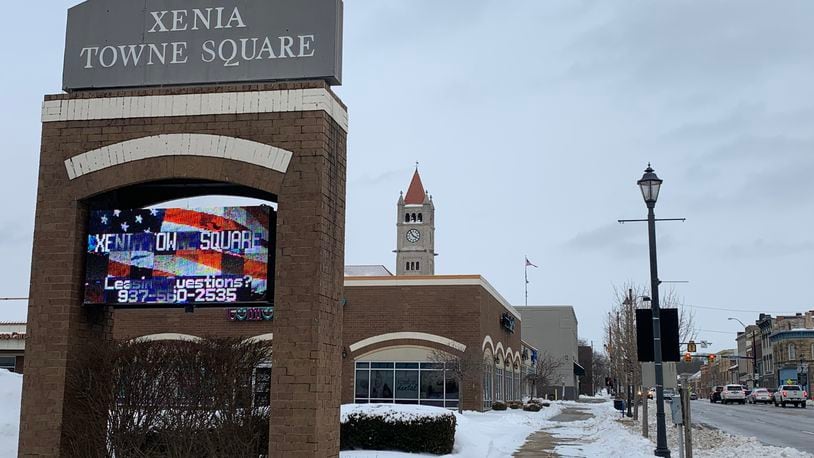 The snowy sign in downtown Xenia marking the city's Towne Square, with the courthouse steeple in the background.