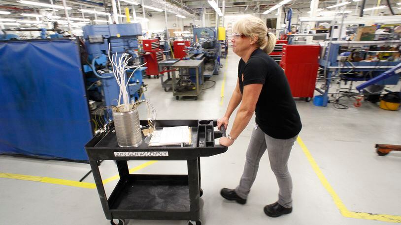Angie Howell, a prodcut development lab assembler at GE Aviation in Vandalia, moves a compont used for electric generation aboard an F-18 Super Hornet in this 2012 file photo. CHRIS STEWART/STAFF