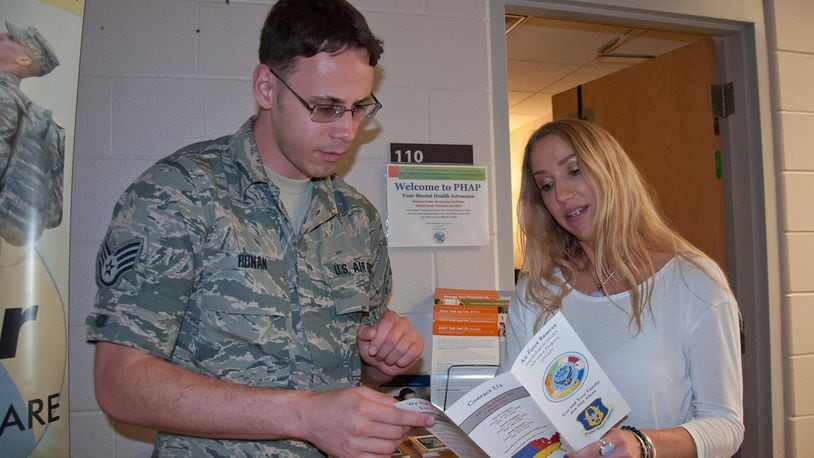 Pamela Boyd, Psychological Health Advocacy Program Outreach Specialist, provides program literature to Staff Sgt. Samuel Ronan, 445th Customer Support NCOIC, to support the 3,000 members of the Reserve squadron June 15. PHAP assists members and families as they deal with life s stressors. (U.S. Air Force photo/John Harrington)