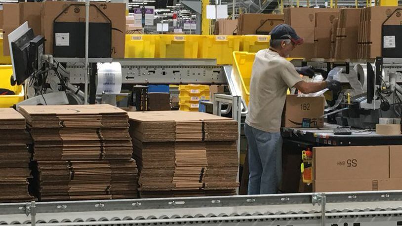 Amazon workers package orders. KARA DRISCOLL/STAFF