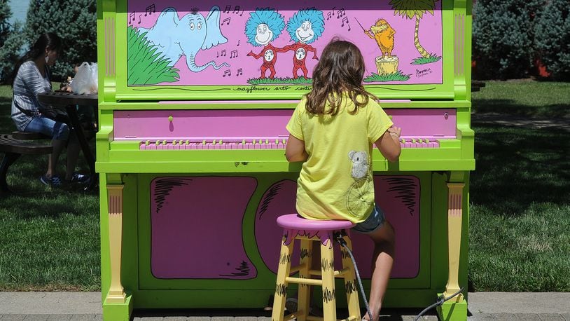 A child plays one of the Painted Pianos in Troy last year, as part of an effort by the Lincoln Community Center, the Troy-Hayner Cultural Center and the Mayflower Arts Center. MARSHALL GORBY\STAFF