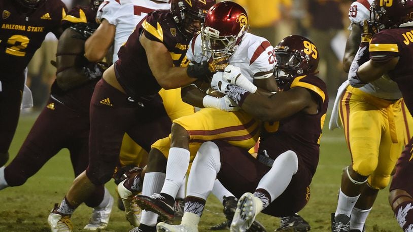 TEMPE, AZ - SEPTEMBER 26: Aca’Cedric Ware #28 of the Southern California Trojans is tackled by Salamo Fiso #58 and Renell Wren #95 of the Arizona State University Sun Devils during the second half at Sun Devil Stadium on September 26, 2015 in Tempe, Arizona. Trojans won 42-14. (Photo by Norm Hall/Getty Images)