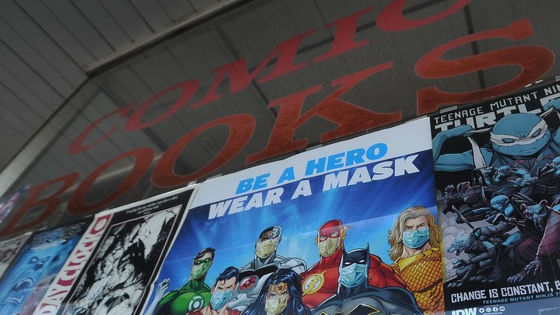 The sign 'Be A Hero Wear A Mask'  greets customers at the Mavericks comic book shop in Kettering. MARSHALL GORBY\STAFF