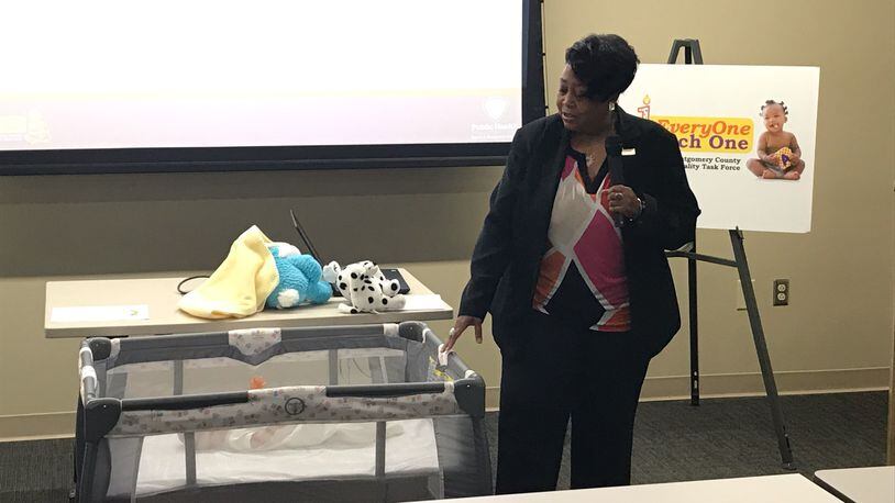 Angela Grayson with Public Health - Dayton & Montgomery County demostrates safe sleep practices. KAITLIN SCHROEDER