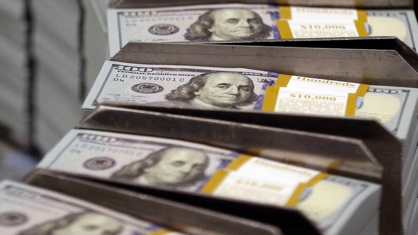 Freshly cut stacks of $100 bills make their way down the line at the Bureau of Engraving and Printing Western Currency Facility in Fort Worth, Texas. More than 6 million adults, including thousands in Ohio age 50-64, are still burdened with student loan debt, according to a new government report. AP Photo