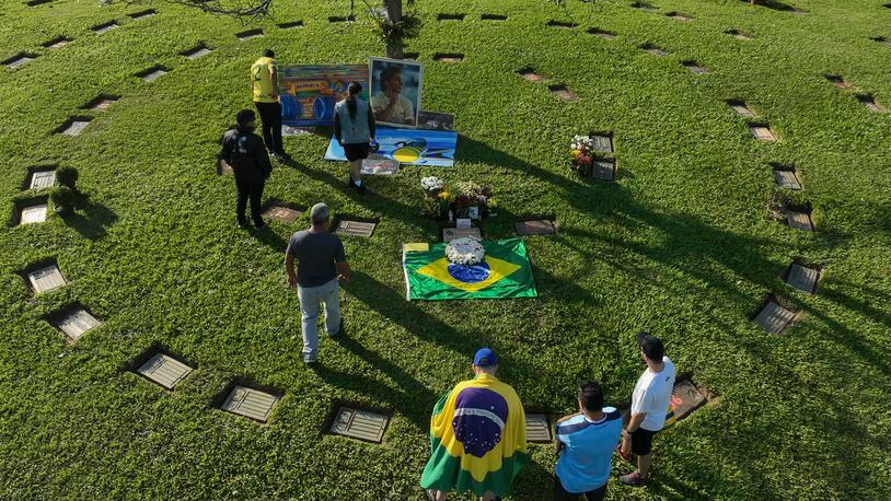Fans gather at the burial site of late Brazilian Formula One driver Ayrton Senna to mark the 30th anniversary of his death, at Morumbi cemetery in Sao Paulo, Brazil, Wednesday, May 1, 2024. The three-time F1 world champion died in a crash at the Imola race track in San Marino. (AP Photo/Andre Penner)