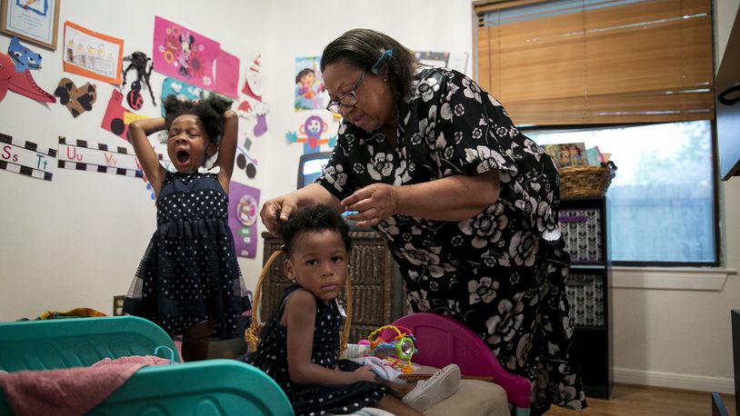 Cheryl Givens-Perkins brushes her granddaughters' hair for church. Givens-Perkins cares for her three grandchildren after her daughter Cassaundra Lynn Perkins died of an infection just over a week after giving birth to her twins. She was 21. (Ilana Panich-Linsman/Los Angeles Times/TNS)