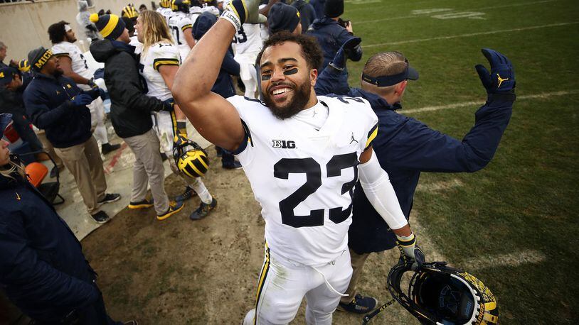 EAST LANSING, MI - OCTOBER 20: Tyree Kinnel #23 of the Michigan Wolverines celebrates on the sideline as the clock winded down on a 21-7 win over the Michigan State Spartans at Spartan Stadium on October 20, 2018 in East Lansing, Michigan. (Photo by Gregory Shamus/Getty Images)