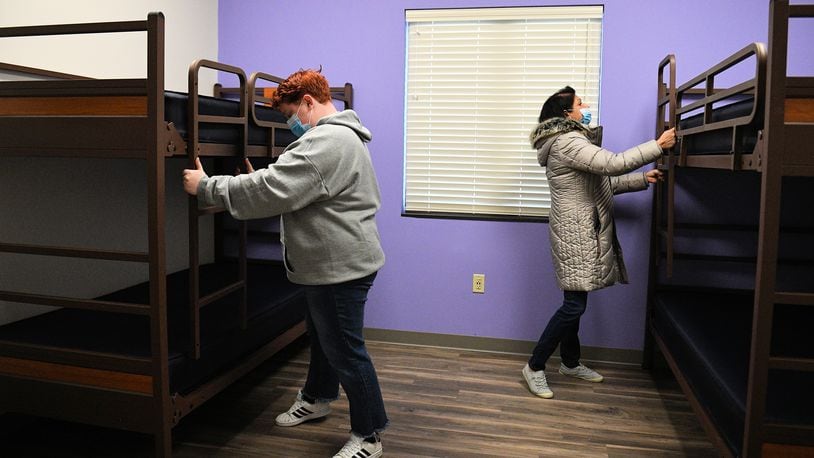 Those helping with the move of the Family Abuse Shelter to its new home on Crescent Drive in Troy work to put the finishing touches on beds in one of the resident rooms.