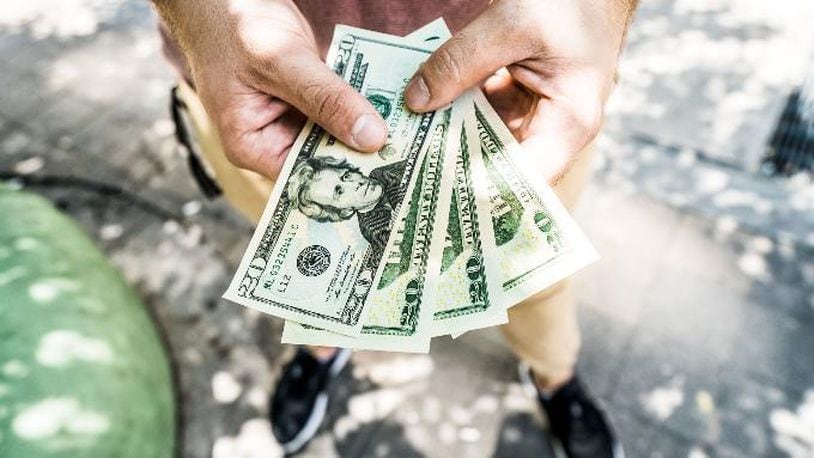 Photo illustration of a man holding money. According to WHBQ, 420 employees of the city of Memphis, Tennessee, are about to get a raise to an hourly rate that is more than twice the state and federal minimum wage average.