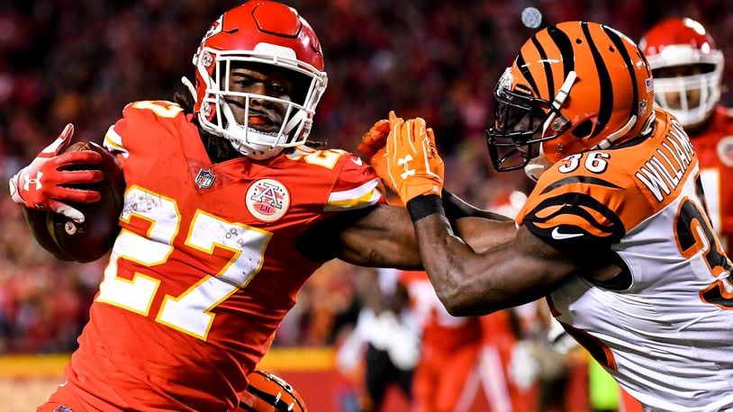Kareem Hunt (left) of the Kansas City Chiefs stiff arms Shawn Williams of the Cincinnati Bengals on his way to a diving touchdown during the second quarter of the game at Arrowhead Stadium on October 21, 2018 in Kansas City, Kansas. (Photo by Peter Aiken/Getty Images)