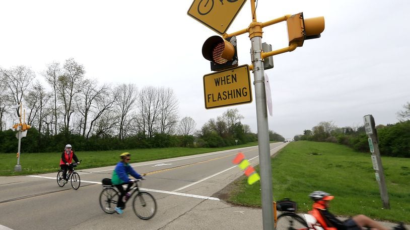 A group of bicylists wait for traffic before crossing US 68 in Clark County on the bike path in this file photo. Bill Lackey/Staff