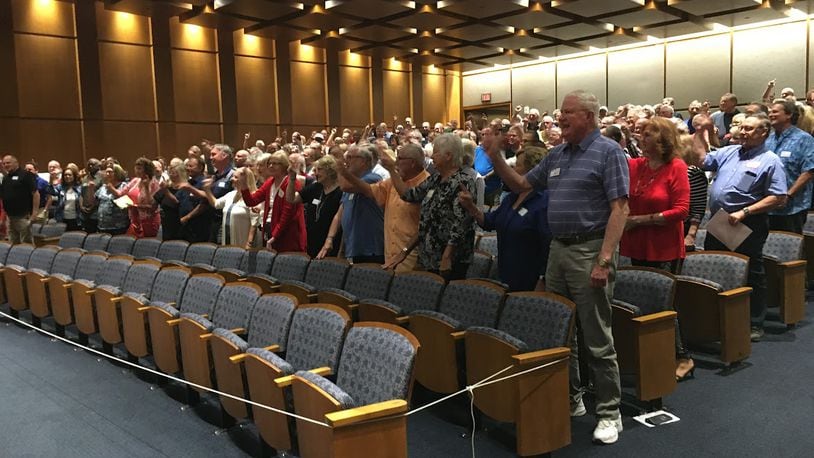 Members of Delphi Salaried Retirees Association stood and chanted "Pass this bill" in September at a Sinclair Community College auditorium. THOMAS GNAU/STAFF