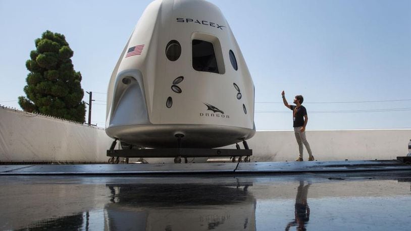 A reporter takes a smart phone photo of a mock up of the Crew Dragon spacecraft during a media tour of SpaceX headquarters and rocket factory on August 13, 2018 in Hawthorne, California. SpaceX plans to use the spaceship Crew Dragon, a passenger version of the robotic Dragon cargo ship, to carry NASA astronauts to the International Space Station for the first time since the Space Shuttle program was retired in 2011.