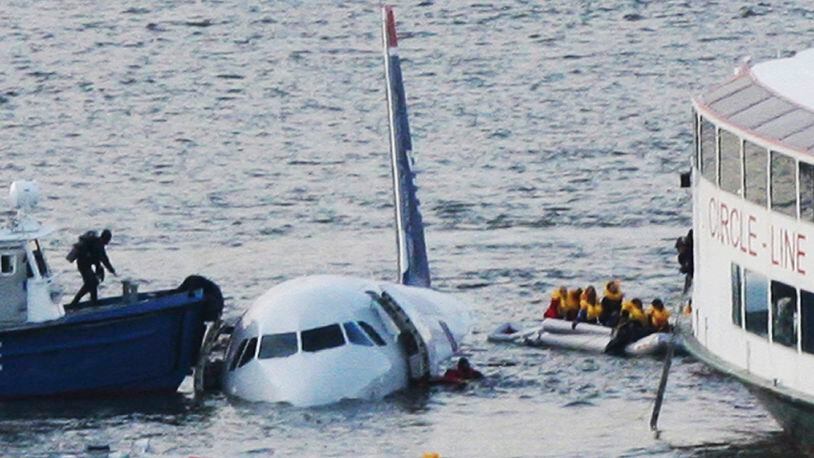 In this Jan. 15, 2009 file photo, a diver, left, aboard an NYPD vessel prepares to rescue passengers that escaped from the Airbus 320 US Airways aircraft made an emergency landing in the Hudson River in New York in what came to be known as the "Miracle on the Hudson" because everyone survived. It's been 10 years since US Airways flight 1549 landed on the Hudson River after colliding with a flock of geese just after takeoff. (AP Photo/Bebeto Matthews, File)