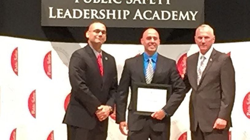 Fairborn Police Department Sgt. Ben Roman, center, poses with Ohio State Highway Patrol Col. Paul Pride, right, and OSHP Lt. Angel Burgos, left, while graduating from the Public Leadership Academy. CONTRIBUTED