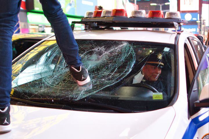 A demonstrator jumps on an NYPD patrol car at Times Square in New York amid protests against police violence following the release of video of the death of Tyre Nichols, on Friday, Jan. 27, 2023. (Ahmed Gaber/The New York Times)