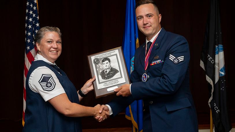 Master Sgt. Dominique Hix, Air Force Sergeants Association, presents Airman Arthur Marais, National Air and Space Intelligence Center, with the John L. Levitow Award at the Chief Master Sgt. Grace A. Peterson Airman Leadership School Class 22-E graduation ceremony on June 16, at Wright-Patterson Air Force Base, Ohio. The John L. Levitow Award goes to the class’s top graduate. U.S. AIR FORCE PHOTO/R.J. ORIEZ