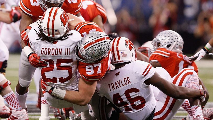 INDIANAPOLIS, IN - DECEMBER 06:  Joey Bosa #97 of the Ohio State Buckeyes tackles Melvin Gordon #25 of the Wisconsin Badgers in the first half of the Big Ten Championship at Lucas Oil Stadium on December 6, 2014 in Indianapolis, Indiana.  (Photo by Joe Robbins/Getty Images)