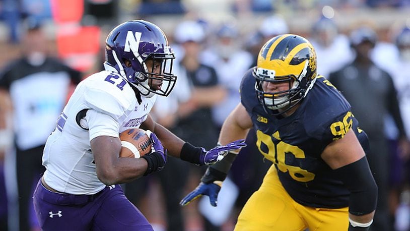 ANN ARBOR, MI - OCTOBER 10: Running back Justin Jackson #21 of the Northwestern Wildcats runs for a short gain as defensive lineman Ryan Glasgow #96 of the Michigan Wolverines gives chase during the third quarter of the game on October 10, 2015 at Michigan Stadium in Ann Arbor, Michigan. The Wolverines defeated the Wildcats 38-0. (Photo by Leon Halip/Getty Images)