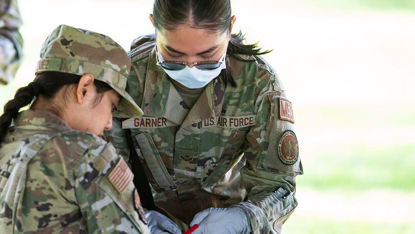 Airman 1st Class Czarina Garner, a medical technician with the 88th Medical Group, checks on “injured” Airmen during a “fuel spill” exercise May 19 at Wright-Patterson Air Force Base. Readiness exercises are routinely held to streamline unit cohesion when responding to emergencies. U.S. AIR FORCE PHOTO/WESLEY FARNSWORTH