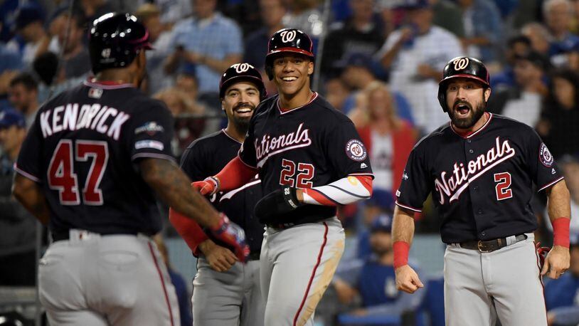 The Nationals' Howie Kendrick celebrates after hitting a grand slam with teammates Anthony Rendon, back left,  Adam Eaton, right, and Juan Soto, center, in the tenth inning of game five of the National League Division Series against the Los Angeles Dodgers at Dodger Stadium on October 09, 2019 in Los Angeles, California. (Photo by Harry How/Getty Images)