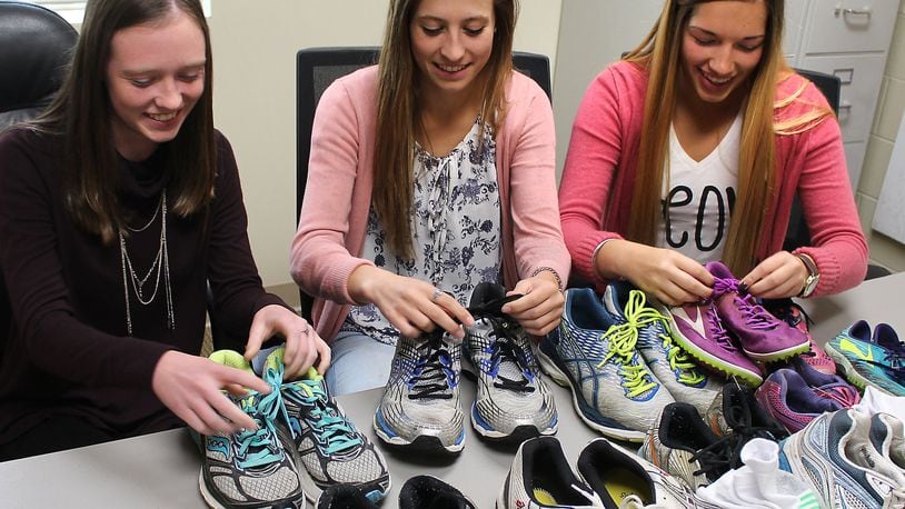 West Liberty-Salem cross-country team members (left to right) Lauren Fowler, Reghan Bieleski and Taylor Henault help collect shoes that will be given to cross-country runners who lost their shoes in Hurricane Harvey. JEFF GUERINI/STAFF