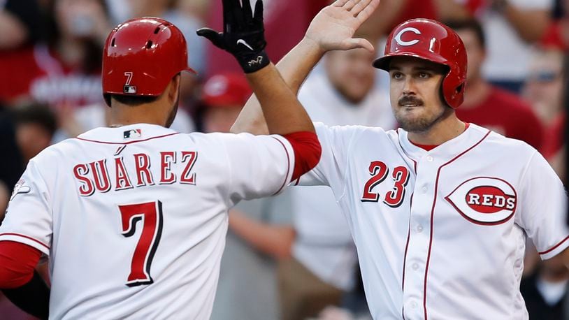 Cincinnati Reds' Eugenio Suarez (7) celebrates with Adam Duvall (23) after hitting a two-run home run off San Diego Padres starting pitcher Travis Wood during the third inning of a baseball game, Wednesday, Aug. 9, 2017, in Cincinnati. (AP Photo/John Minchillo)