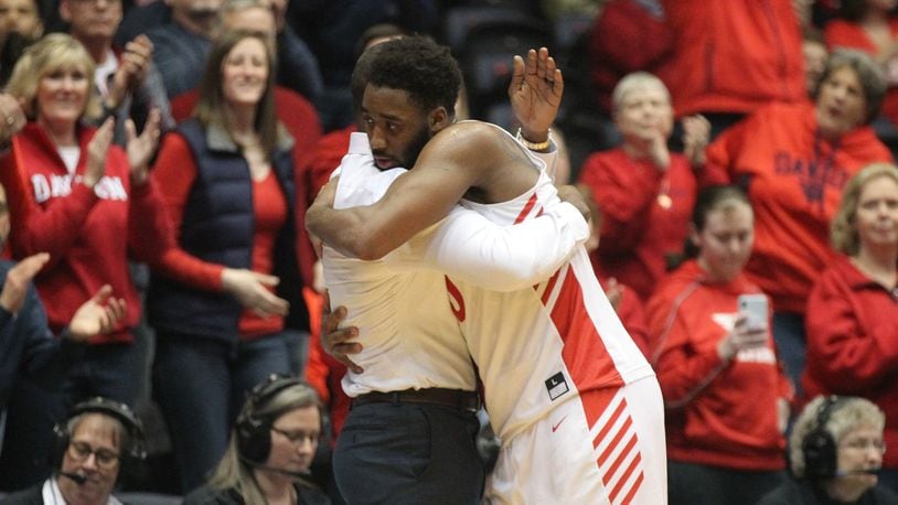 Dayton’s Josh Cunningham hugs Anthony Grant after leaving the court in his final home game against La Salle on Wednesday, March 6, 2019, at UD Arena. David Jablonski/Staff