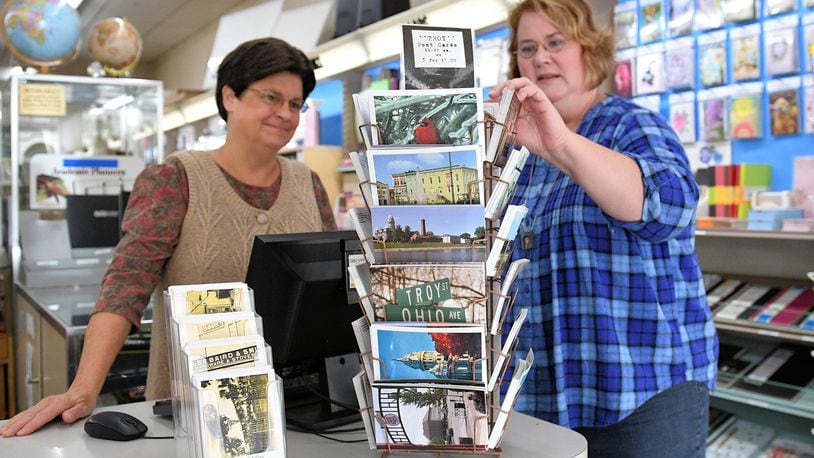 Lori Brower (left) and Diana Brower look through postcards – including several new – at Brower's Stationers in downtown Troy. CONTRIBUTED