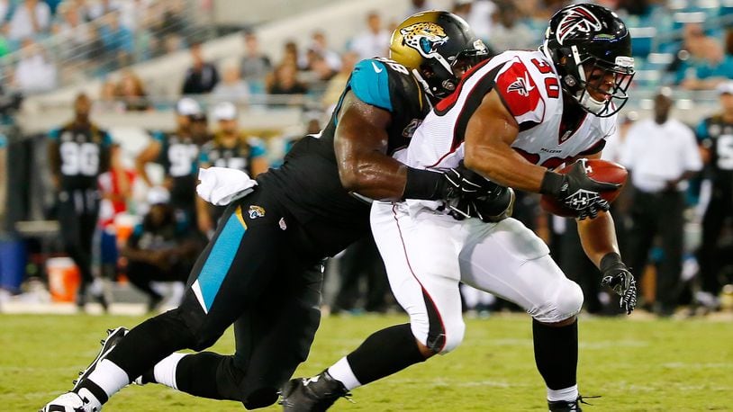 JACKSONVILLE, FL - AUGUST 28: Josh Vaugh #30 of the Atlanta Falcons runs against Chris Smith #98 of the Jacksonville Jaguars during the preseason NFL game at EverBank Field on August 28, 2014 in Jacksonville, Florida. (Photo by Sam Greenwood/Getty Images)