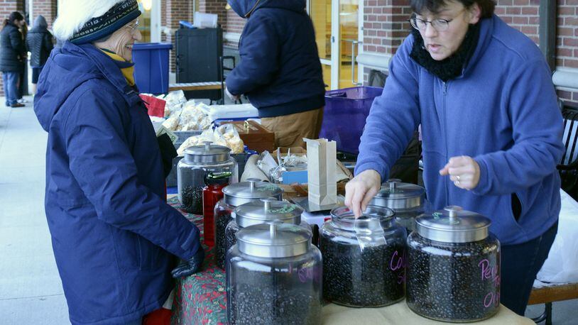 Debra Liston, owner of Mwimbula Coffee Roasters, serves a customer last year at Fairfield’s Winter Farmers Market at the Community Arts Center. The winter market runs the second Wednesday of each month through April. MICHAEL D. PITMAN/STAFF