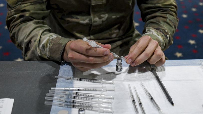 FILE — A soldier prepares vaccine doses for administration at Fort Bragg, N.C., Feb. 24, 2021. American soldiers who have yet to be vaccinated against the coronavirus will be immediately discharged, the Army said on Wednesday, Feb. 2, 2022, joining other branches of the military, including the Air Force, that have already begun dismissing vaccine holdouts. (Kenny Holston for The New York Times)