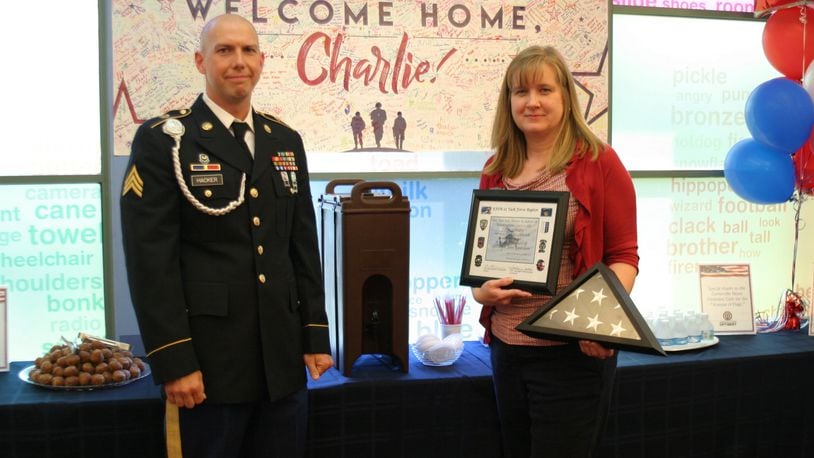 Sgt. Charlie Hacker presents a flag that was flown in Kosovo in honor of the Washington-Centerville Public Library to WCPL assistant director Liz Fultz at his welcome-home party Aug. 2. PAMELA DILLON/CONTRIBUTED