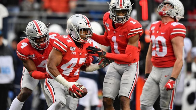 COLUMBUS, OH - NOVEMBER 23:  Justin Hilliard #47 of the Ohio State Buckeyes celebrates with teammates /bbd4 #4 and Jeff Okudah #1 after intercepting a Penn State Nittany Lions pass in the fourth quarter at Ohio Stadium on November 23, 2019 in Columbus, Ohio. Ohio State defeated Penn State 28-17.  (Photo by Jamie Sabau/Getty Images)